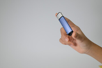 Close-up of a hand holding a blue USB flash drive