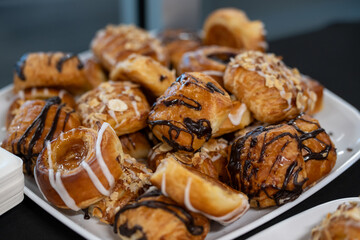 Dish full of pastries drizzled with chocolate and almonds