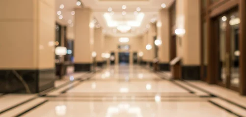 Fototapete Hotel Chic Blurred modern hotel lobby interior with warm color tones, polished surfaces, and structured lighting. Depth of field highlights architectural lines, suitable for hospitality backgrounds.  © AJI EGY TAMA