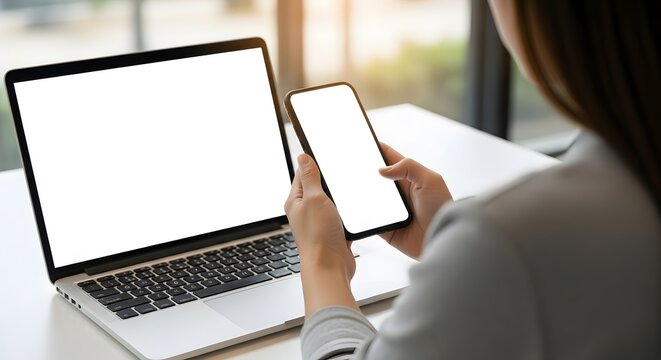Businesswoman Uses Smartphone and Laptop with Blank Screen Mockup for Technology Concept - Powered by Adobe