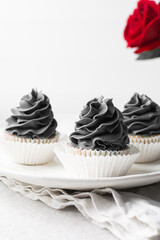 grey frosting on cupcakes with a white background, cupcakes in white liners with tall buttercream swirl, grey buttercream frosted cupcakes on a white background