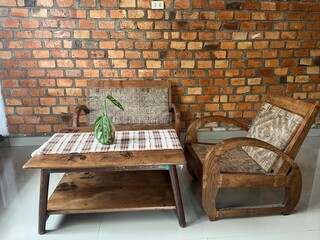 Rustic Wooden Furniture With Green Plant Decoration Against Brick Wall Interior