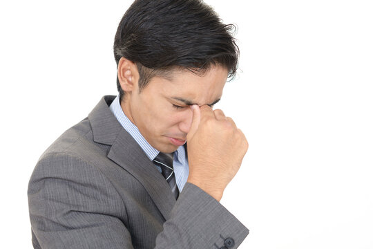 目頭を押さえる男性