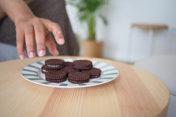 Hand reaching for cookies on a plate in cozy setting