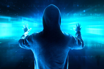 Back view of hacker in hoodie stealing data