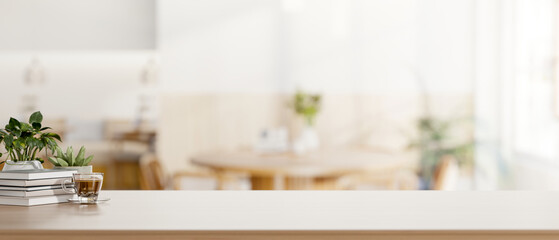Books and coffee in glass cup with pot plant on wooden counter across table in a living room or cafe