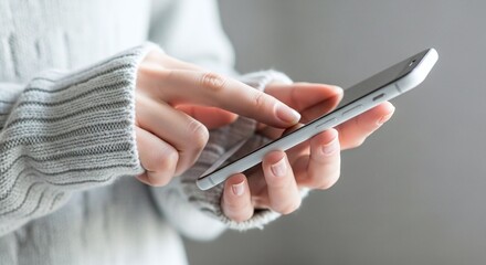 Close up of a person holding and using a smartphone with their fingers on the screen in a casual setting