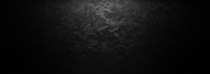 A dark, textured surface with a light source casting shadows.