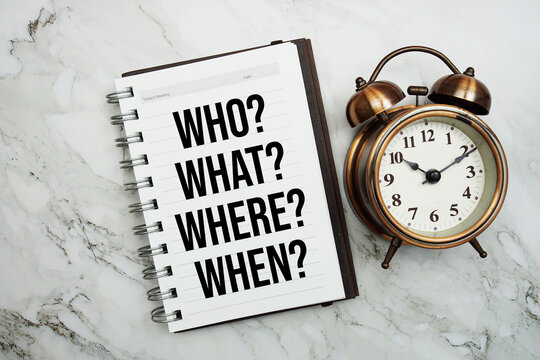 Who, What, Where And When text written on notepad with alarm clock