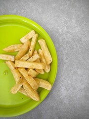 French fries served on a green plate.