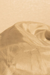 Obraz premium Golden color background, close-up photograph showcasing the delicate texture and movement of highly sheer, lightweight fabric. 
