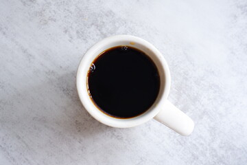 コーヒー - 淹れたてのコーヒーが入ったマグカップを、真上から俯瞰したイメージ
