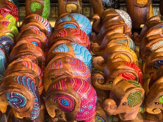 Colorful wooden elephant sculptures with intricate painted details on display