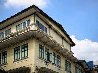 Architectural details of a building with green window frames against a blue sky