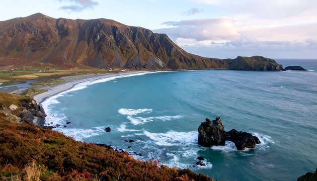 Breathtaking panoramic view of a rugged, remote bay with a pristine sandy beach, dramatic coastal mountains, and a striking sea stack emerging from the turquoise waters under a vast sky