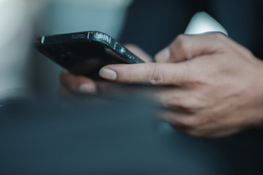 Close-up of business man hands holding smartphone, surfing the internet, checking social media and using mobile applications. Modern communication concept.
