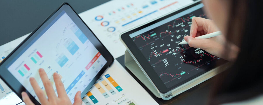 Business professionals analyzing financial data on tablets during a meeting