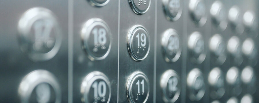 Close-up of elevator buttons with numbers, including 19, 18, 17, and more