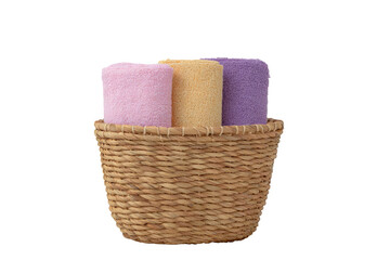Rolled towels in a woven basket, isolated against a dark background