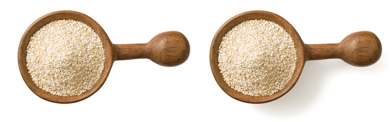 Uncooked oat bran in the wooden spoon, isolated on white background, top view.