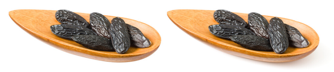 Tonka beans in the wooden plate, isolated on white background.