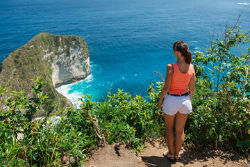 Woman and paradise Kelingking beach in Nusa Penida island, Indonesia.