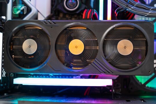 Close-up of a high-performance computer cooling system featuring a sleek triple fan design with vibrant lighting. Ideal for tech enthusiasts and modern gaming setups.