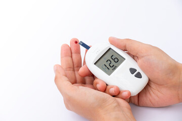Woman's hands checking diabetes and hyperglycemia with digital blood sugar meter. Healthcare and medical concept	