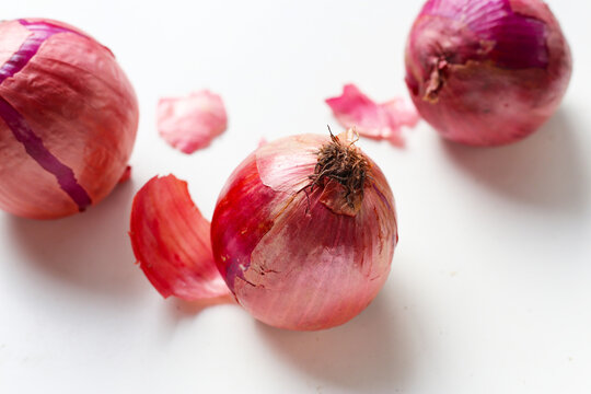 Whole red onions and their skins scattered - Powered by Adobe