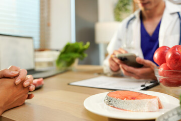 Dietician, male nutrition specialist consulting woman, developing healthy diet, dietary program. Dietary consultant asking, giving male patient advice, help, nutritional information, new meal plan