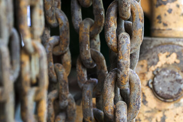 Close up view of an old rusty metal chain link. weathered industrial texture shows strength and connection, with blurred background creating sense of powerful decay