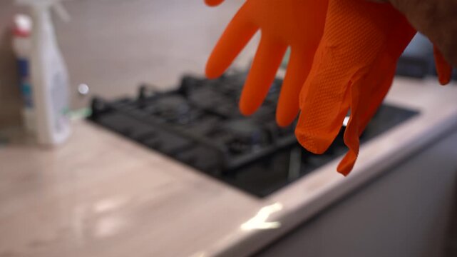 A Close-Up of Hands Preparing to Don Bright Orange Gloves, Emphasizing the Importance of Safety and Cleanliness in Everyday Tasks.