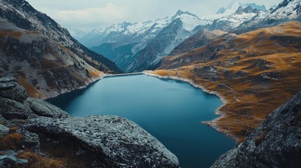 Serene mountain lake surrounded by peaks under a cloudy sky in the early afternoon