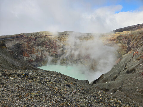 Unique landscape of the crater of Nakadake in Mount Aso Japan with rock and mountain background