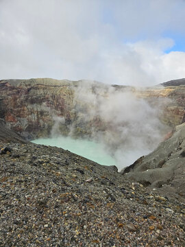 Unique landscape of the crater of Nakadake in Mount Aso Japan with rock and mountain background