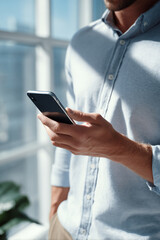 A man is holding a cell phone in his hand