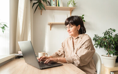 Senior woman working laptop remote at home office