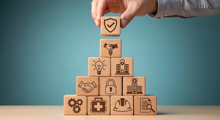 Hand stacking wooden blocks with icons representing safety, security, and business growth, symbolizing a secure and prosperous future