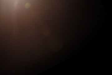Soft Brown Lens Flare with Gentle Glow in Top Corner on Black Background, Abstract Artistic Light, Warm and Subtle Visual, Minimalist Modern Backdrop for Creative Design and Presentations

