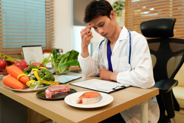 professional nutritionist in uniform writing notes on the table with different healthy products and drawings on the topic of healthy eating