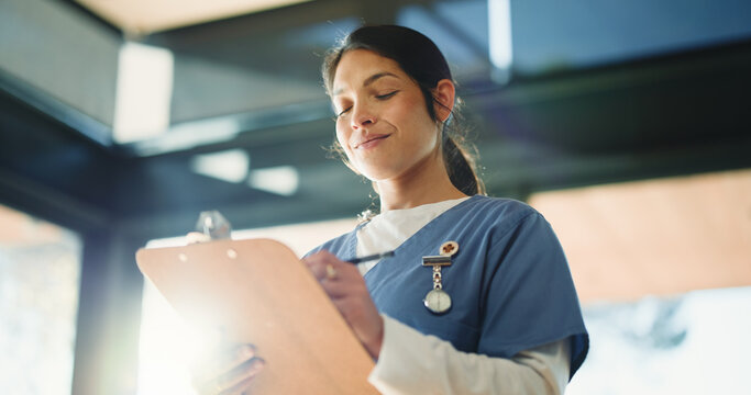 Doctor, happy woman or reading with clipboard in clinic, medical record or writing instructions for care plan. Healthcare, patient treatment or person review chart for information, flare or low angle
