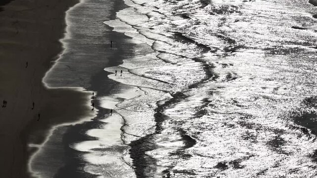 People silhouettes walking on the beach