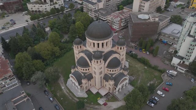 Aerial overhead circling shot showing Catedrala Adormirea Maicii Domnului surrounded by evening colors.