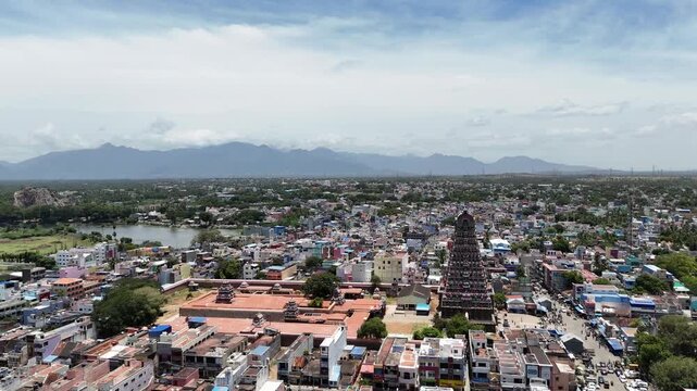 Drone video of Tenkasi&rsquo;s historic Kasi Viswanathar Temple surrounded by colorful town buildings, a lake, and the scenic Western Ghats in the background. mix of modern and traditional buildings