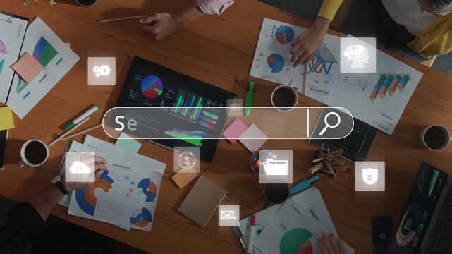 A diverse team is engaged in vibrant collaboration around a table. Digital icons and charts highlight innovation and teamwork in a modern workspace. Raster - Powered by Adobe