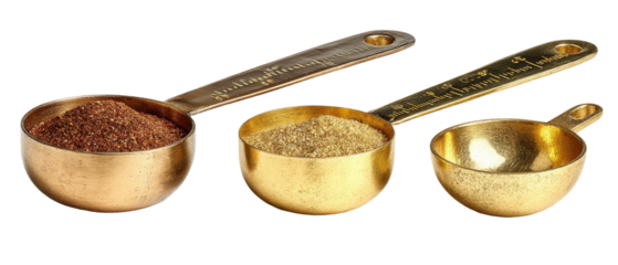 Three intricately designed gold measuring cups filled with various spices, placed on a clean surface, showcasing the textures and colors of the ingredients, ideal for culinary use