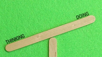 Thinking Versus Doing Concept: Imbalanced Wooden Popsicle Stick Scale Showing More Action Than Contemplation