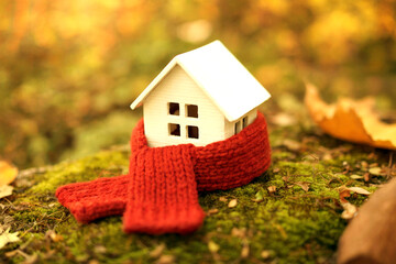 Cozy Mini House Wrapped in Red Knitted Scarf Symbolizing Warmth and Comfort