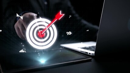 Conceptual image of a hand reaching for a digital target symbol, representing goals, strategy, and data analysis in a modern, innovative workspace setting. Qubit