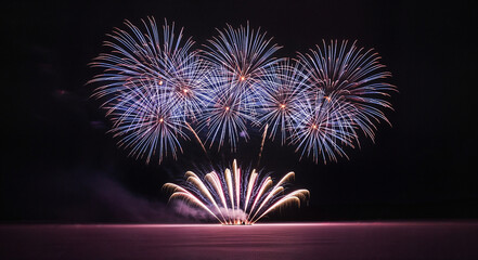 Colorful fireworks exploding in the night sky over water